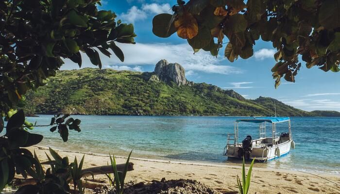 Strand met een bootje in het water op Fiji