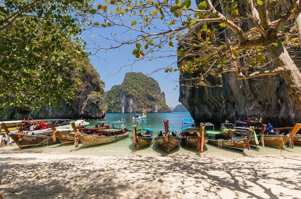Strand met bootjes en bergen in Thailand