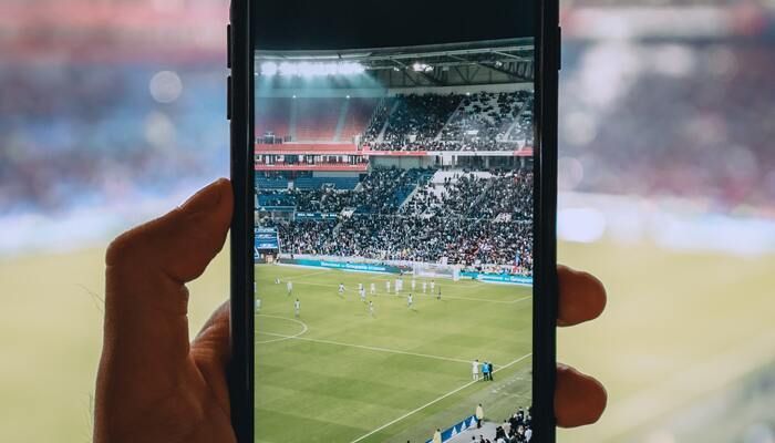 Foto met mobiel in een voetbal stadion